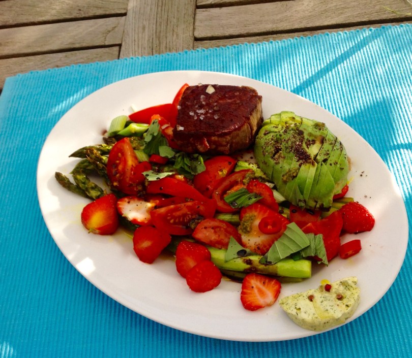 grüner Spargel mit Erdbeeren, Tomatenspalten, Chileringen, Avocado und Stak vom Grill mit Kräuterbutter