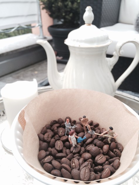 Miniaturfiguren arbeiten in Kaffeebohnen