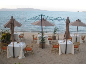 Tische und Schirme am Strand zum abendlichen Barbecue